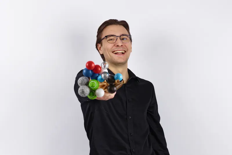 Jacob Kryger smiling and holding out a handful of marimba mallets